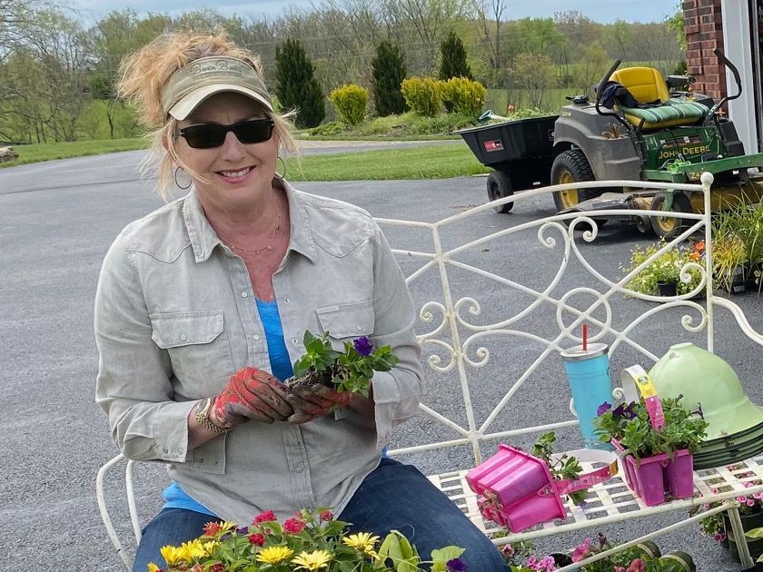 A woman is sitting on a bench holding flowers