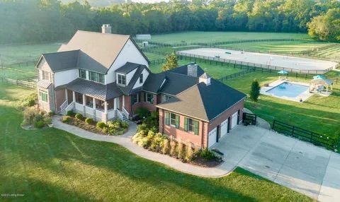 An aerial view of a large house with a pool in the backyard.