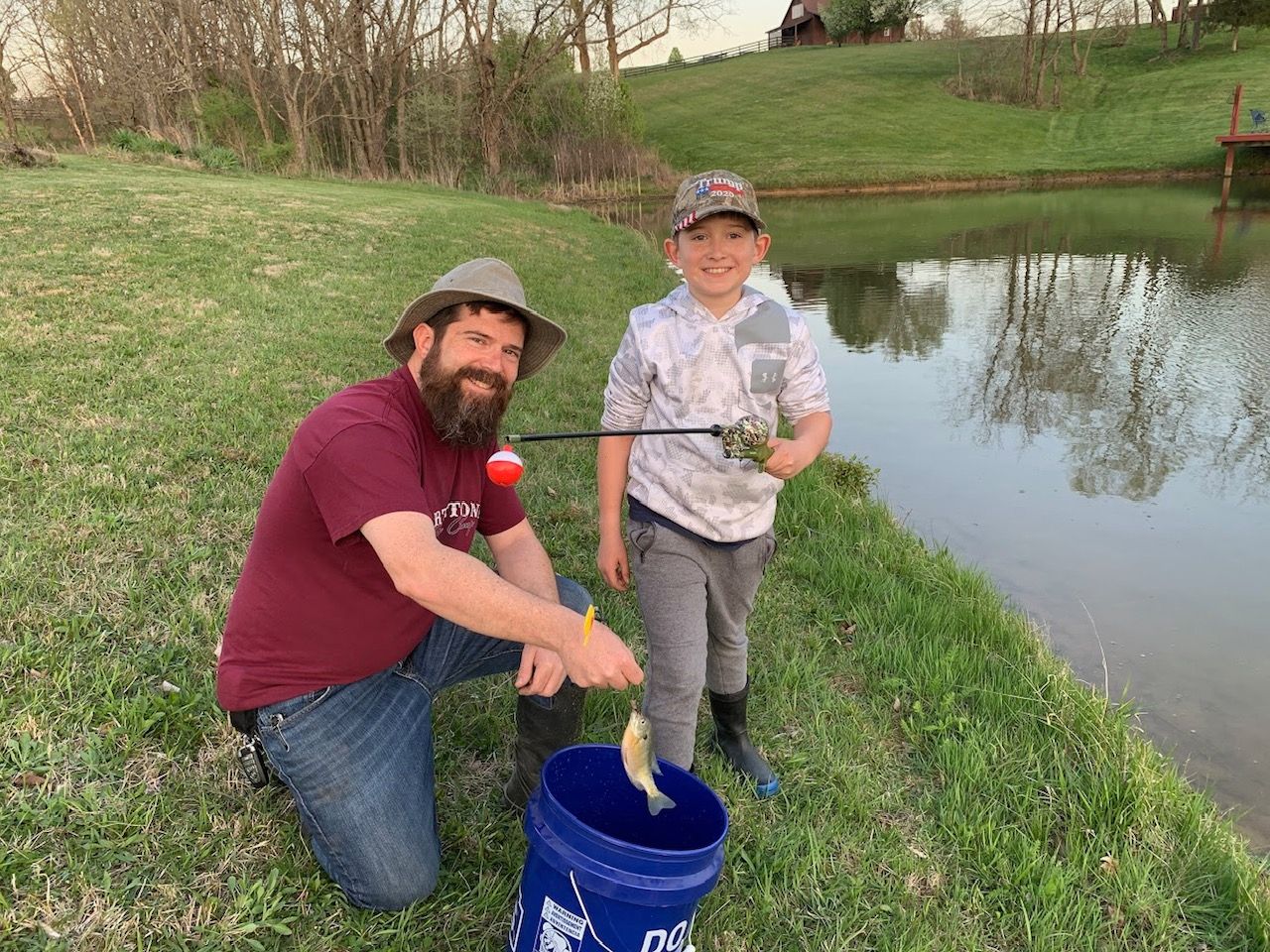 A man and a boy are fishing in a pond.