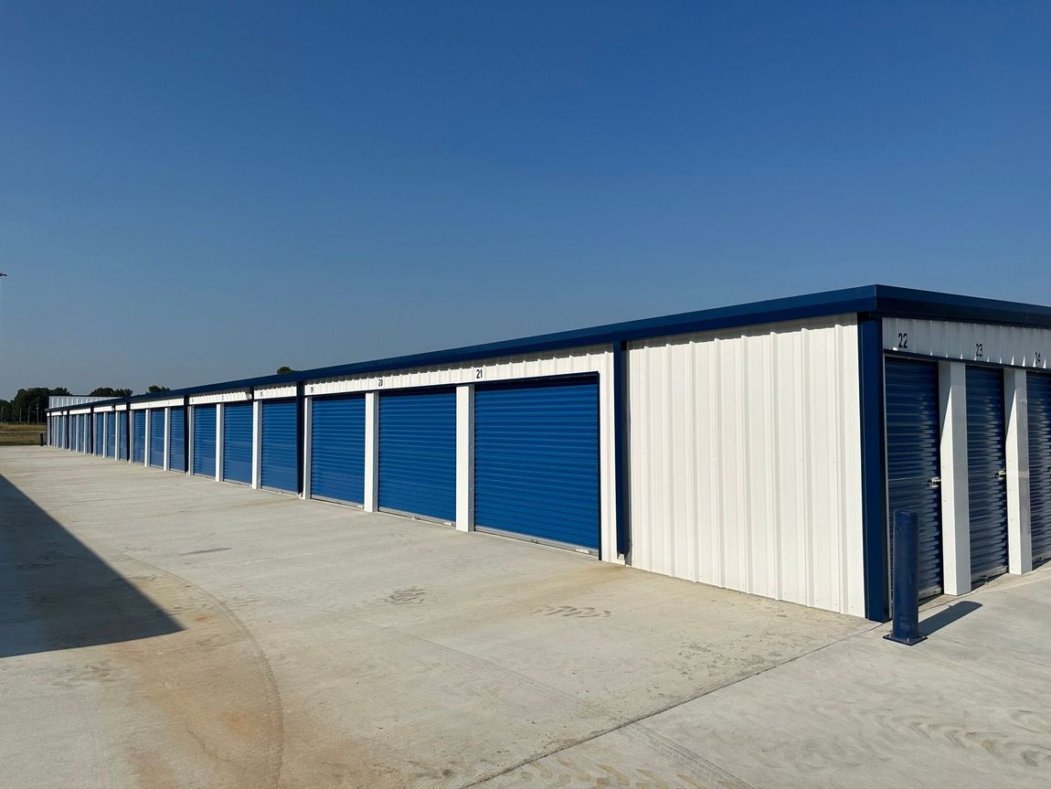 Row of blue and white storage units under a clear blue sky.