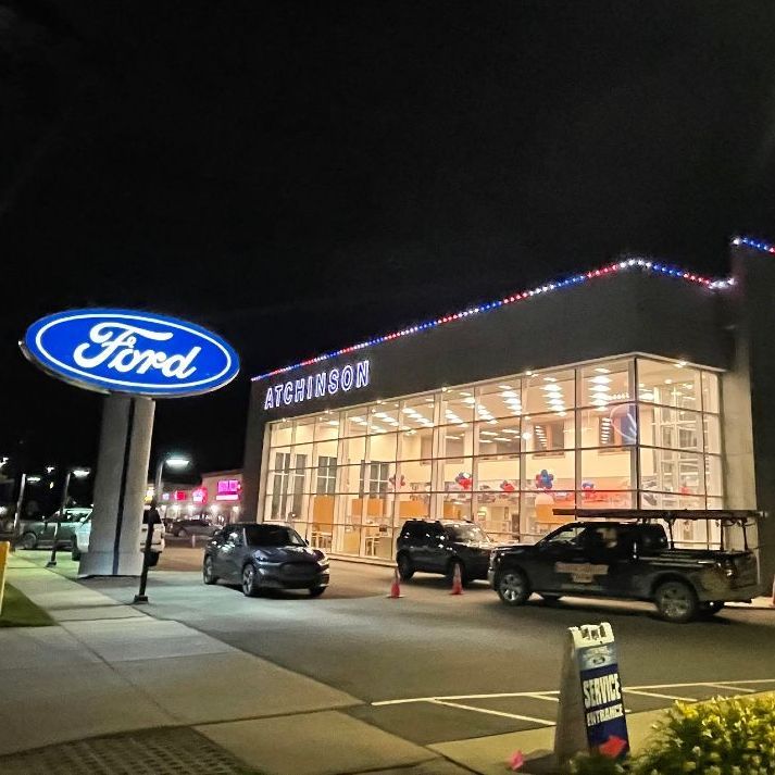 A ford dealership is lit up at night