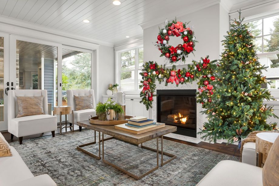 Cozy living room decorated for Christmas, featuring a fireplace, Christmas tree, and garland.