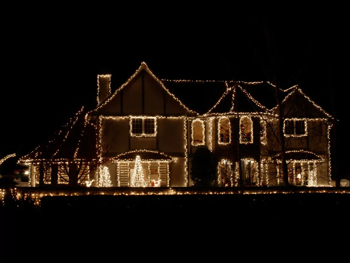 A house decorated with christmas lights is lit up at night by Next Gen Christmas Decor