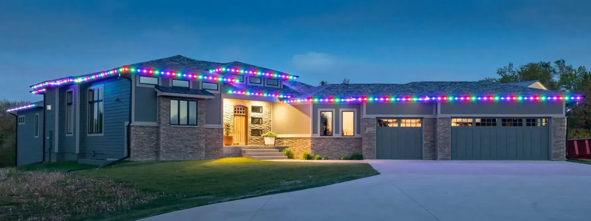 A house with christmas lights on the roof at night.