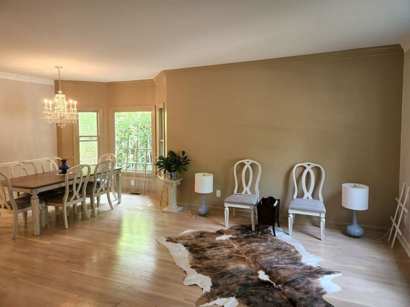 Dining room with light wood floors, table, chairs, cowhide rug, and neutral walls.