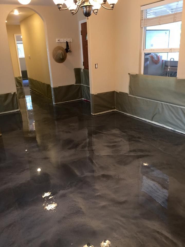 A living room with a black floor and a chandelier