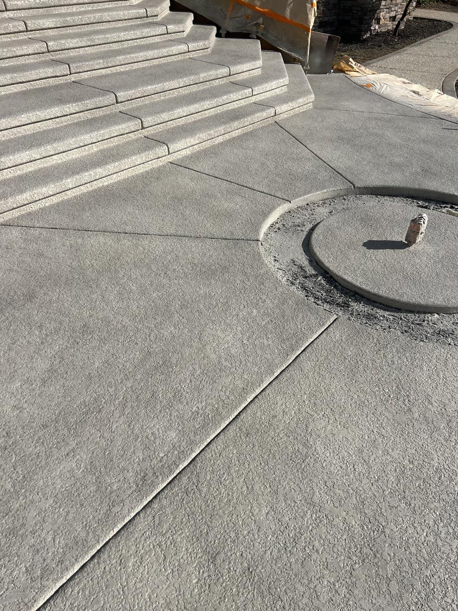 A close up of a concrete walkway with stairs in the background.