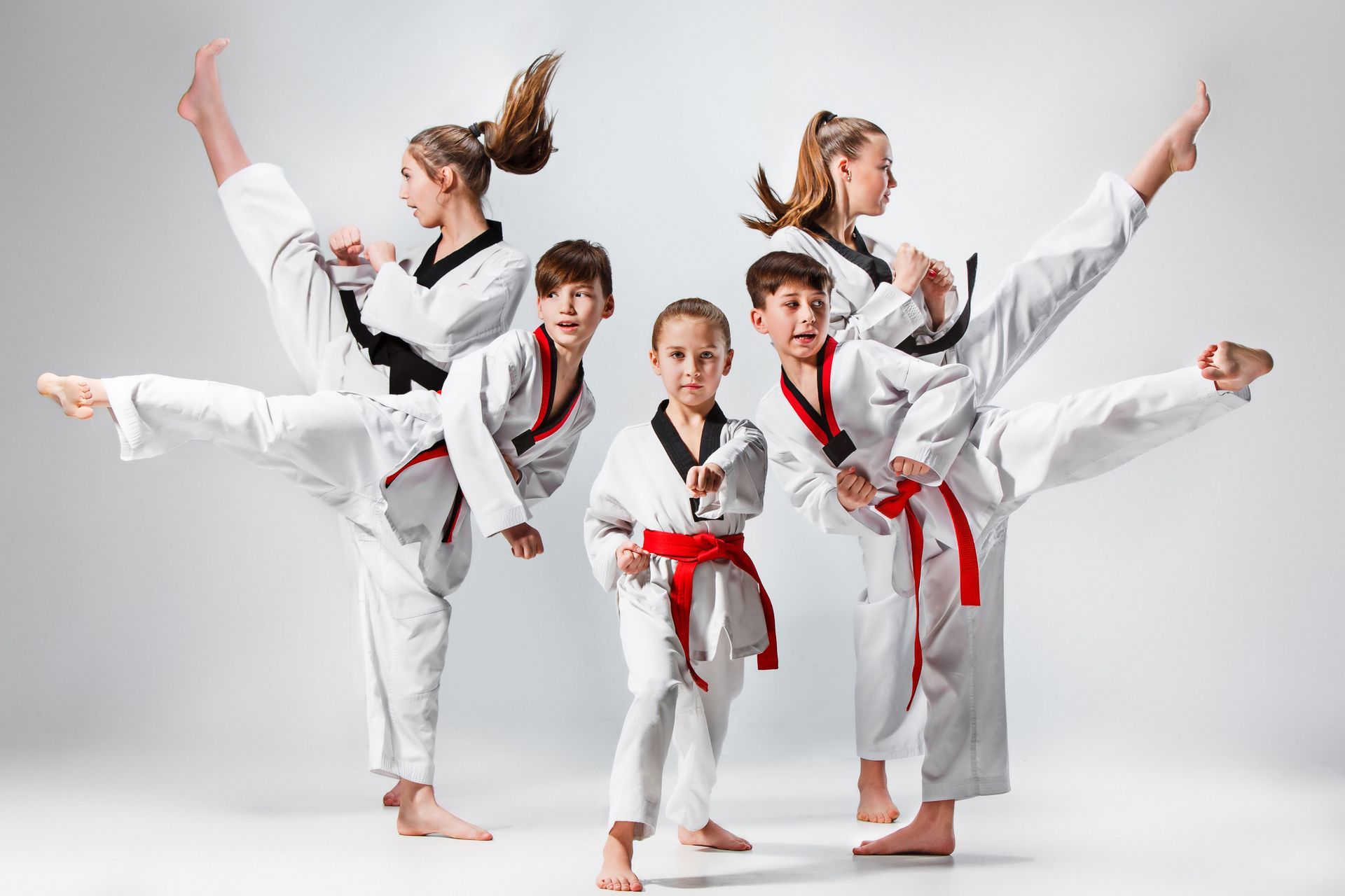 A studio shot of a group of kids practising karate martial arts. A studio shot of a group of kids practising karate martial arts.