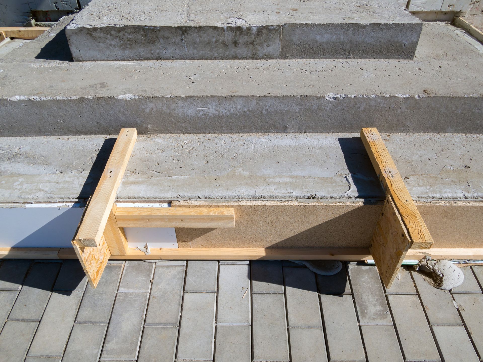 A wooden beam is sitting on top of a concrete staircase