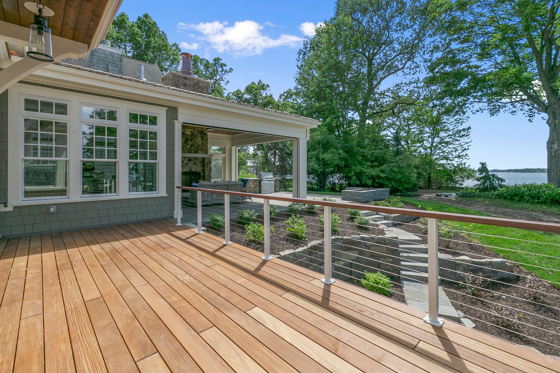 A wooden deck with a railing and a house in the background