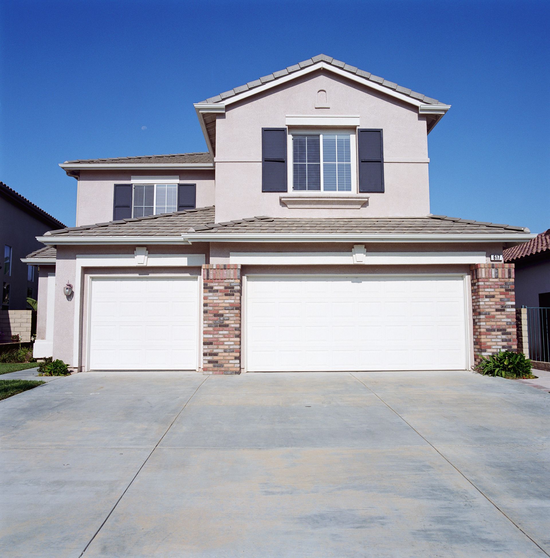 A house with two garage doors and a window with the letter c on it