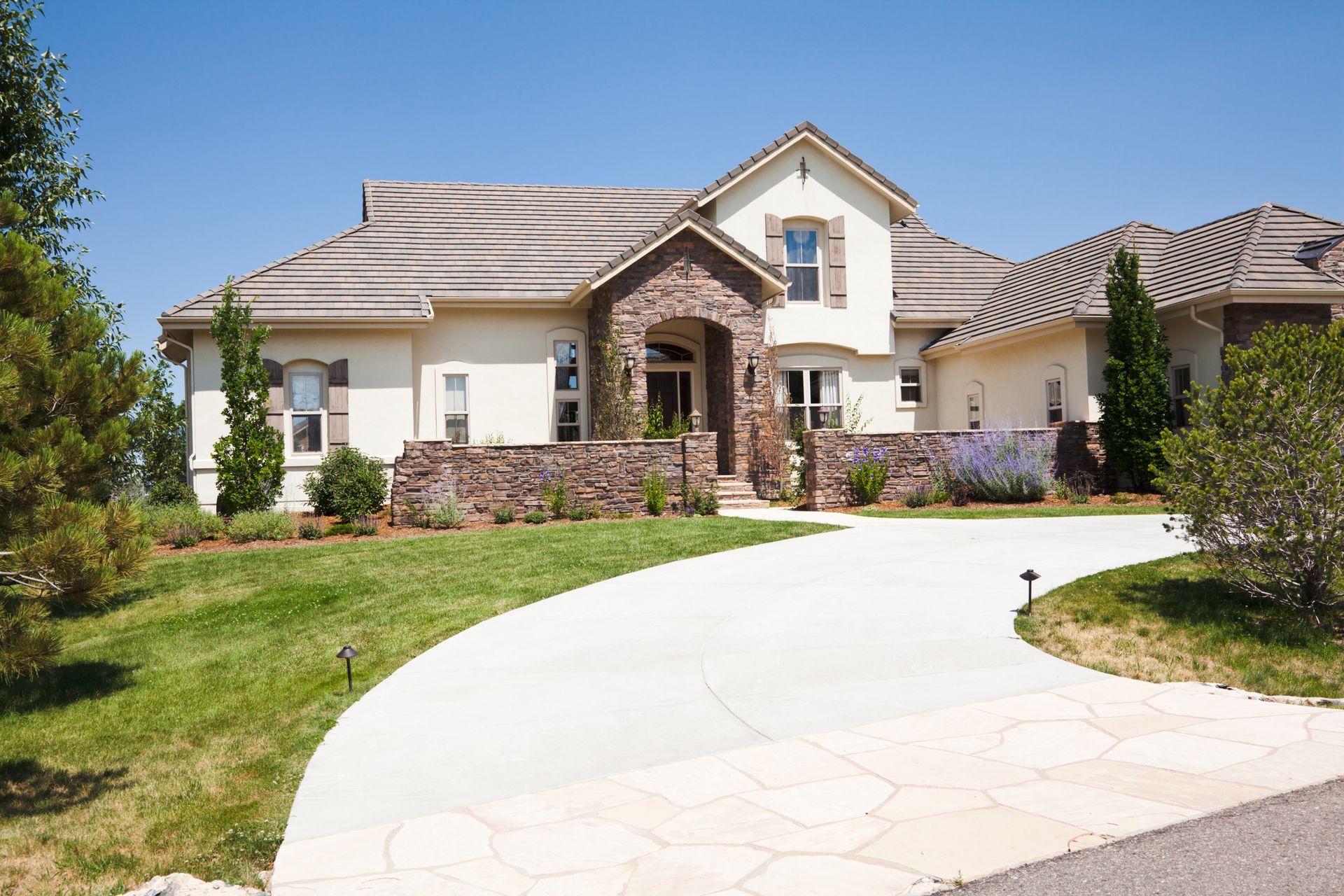 A large house with a concrete driveway leading to it