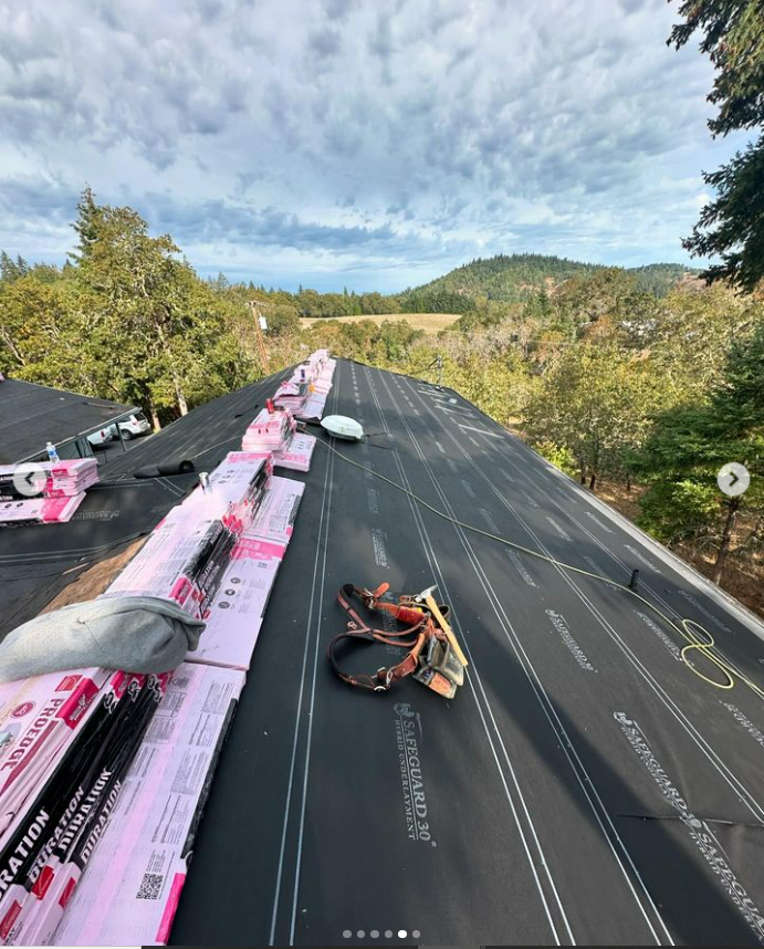 A person is working on a roof with a lot of roofing materials on it.