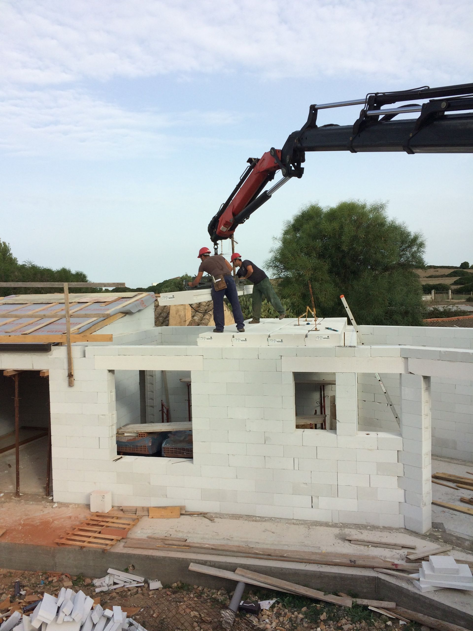 lavoratori su un tetto che ristrutturano una casa bianca