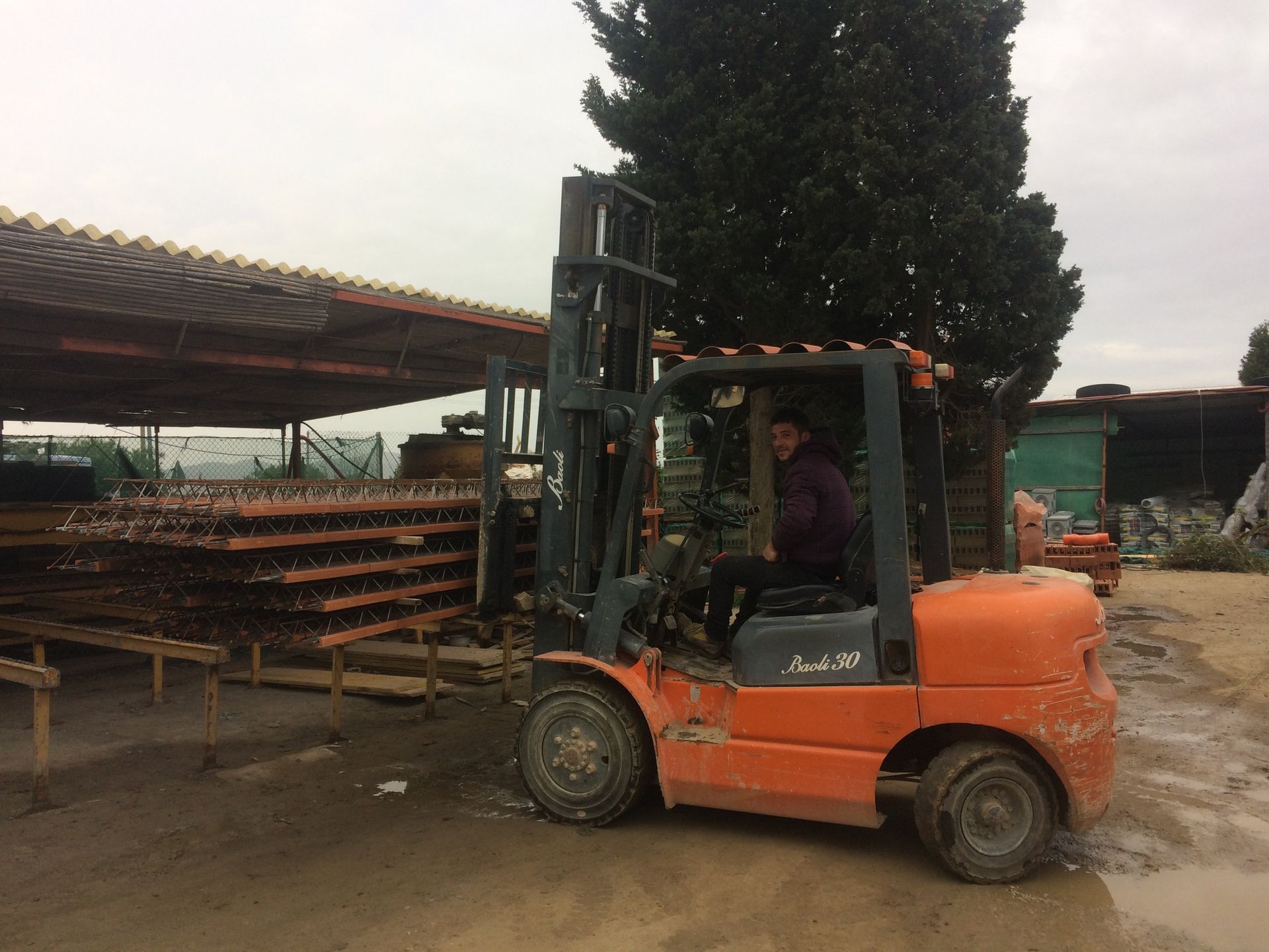 muletto arancione con operaio che lo guida