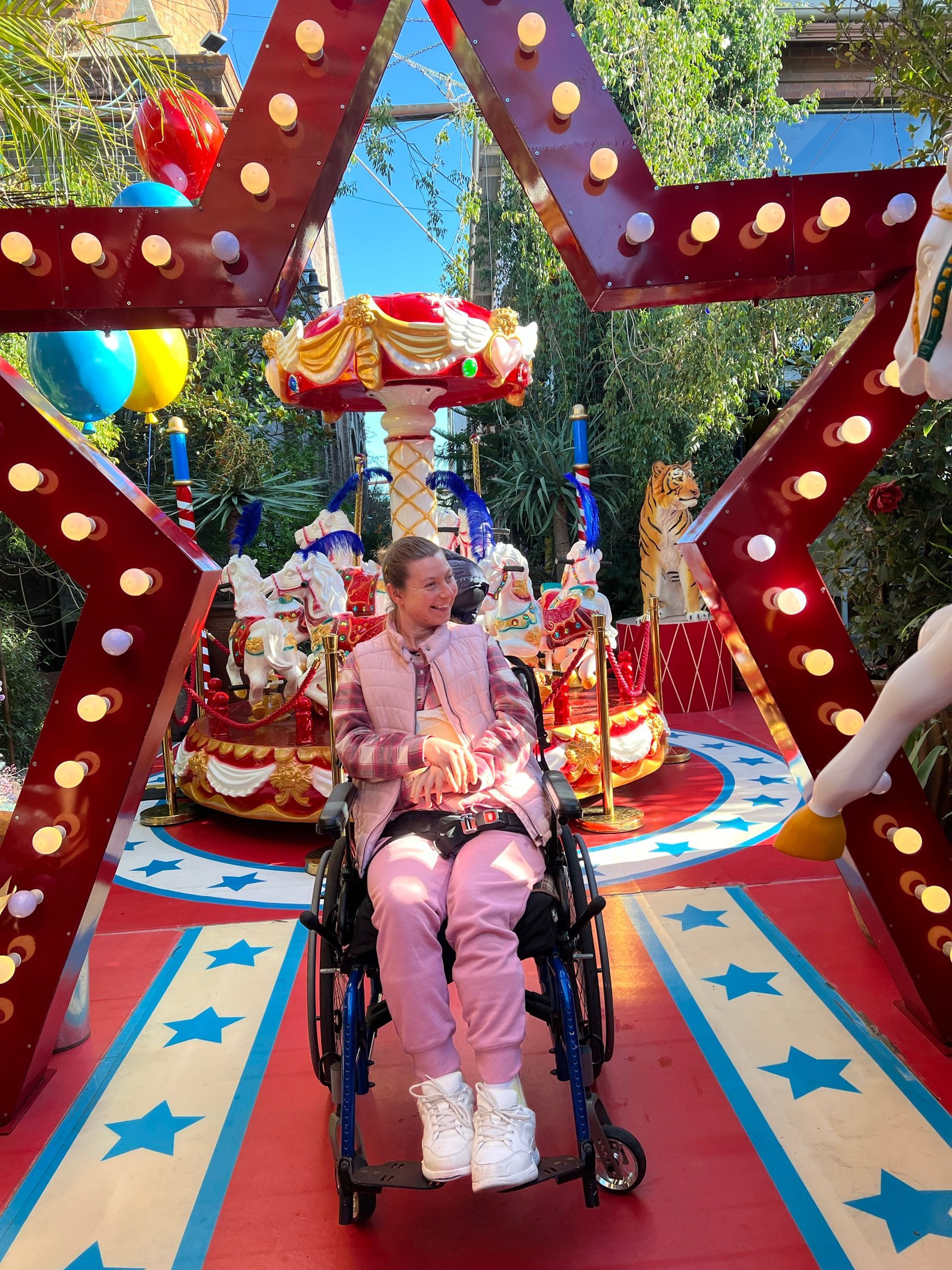 A woman in a wheelchair in front of Christmas star and decorations in a garden