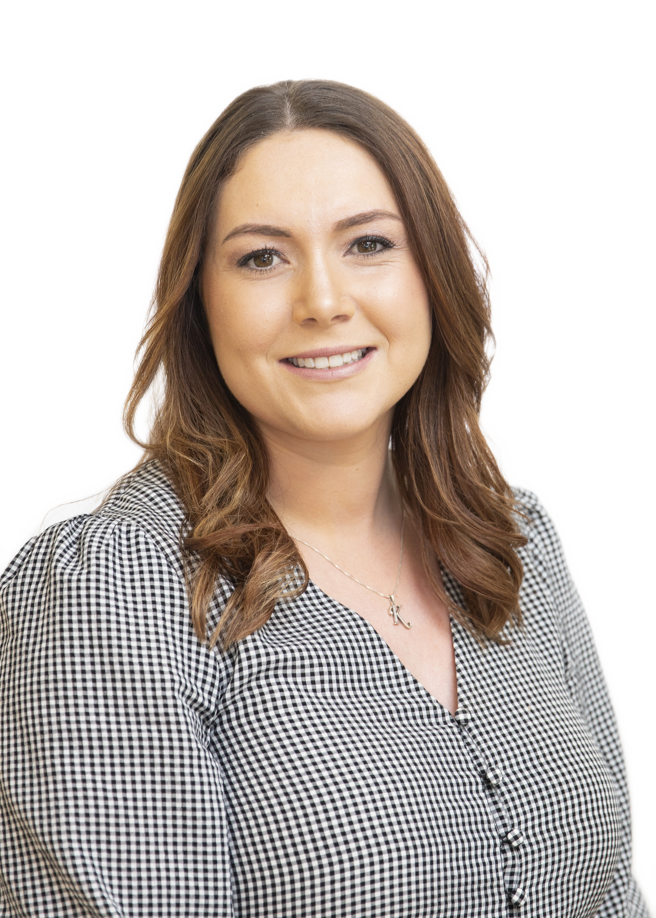 A woman smiling wearing a check shirt 