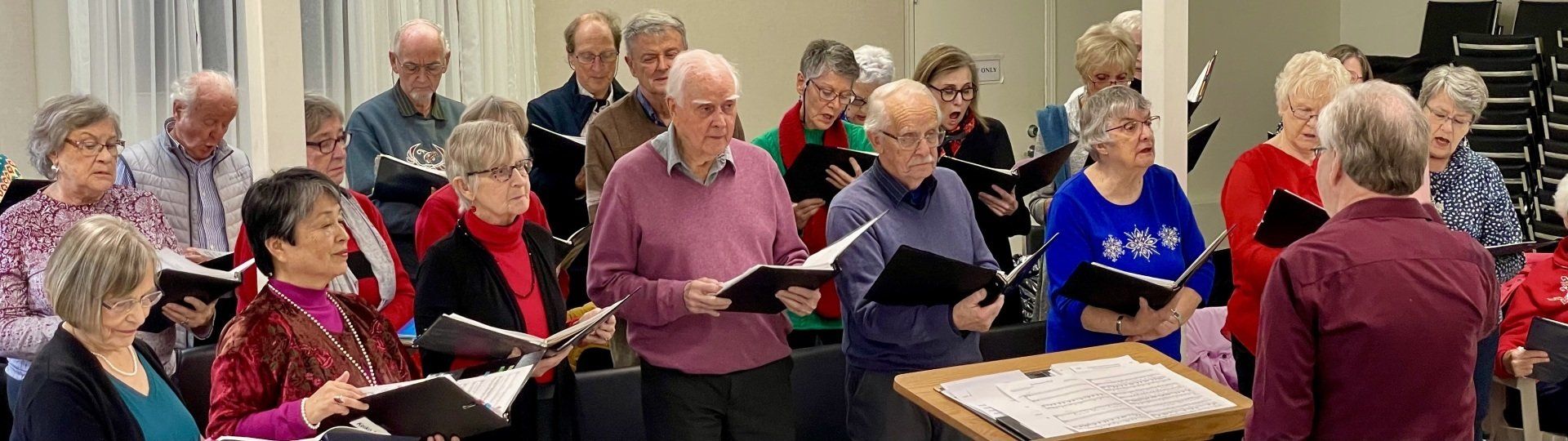A large group of people are singing in a choir.