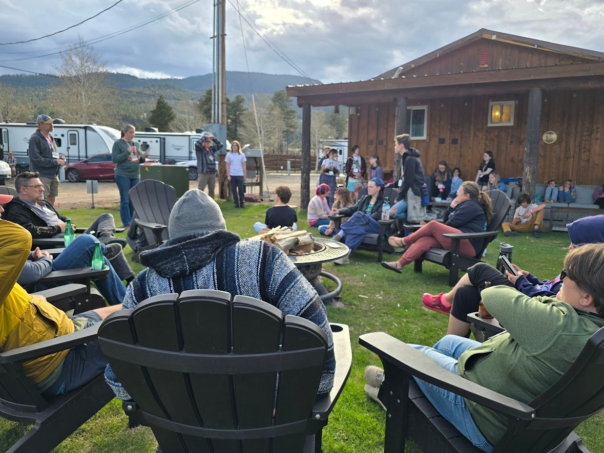 A group of people are sitting in lawn chairs in front of a building.