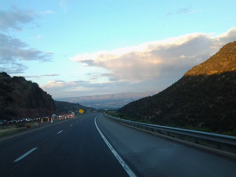 A highway going through a valley with mountains in the background