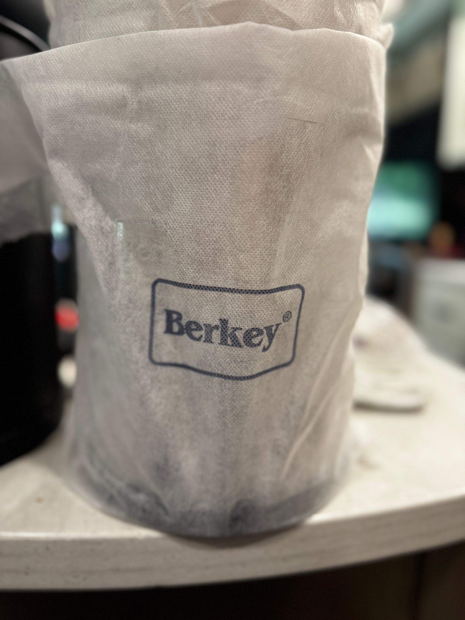 Berkey water filter in protective wrapping. Blue logo on front.