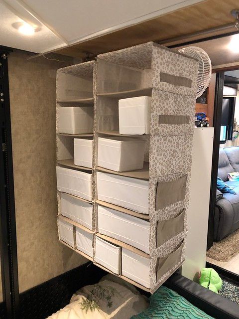 A shelf with boxes on it is hanging from the ceiling in a room.