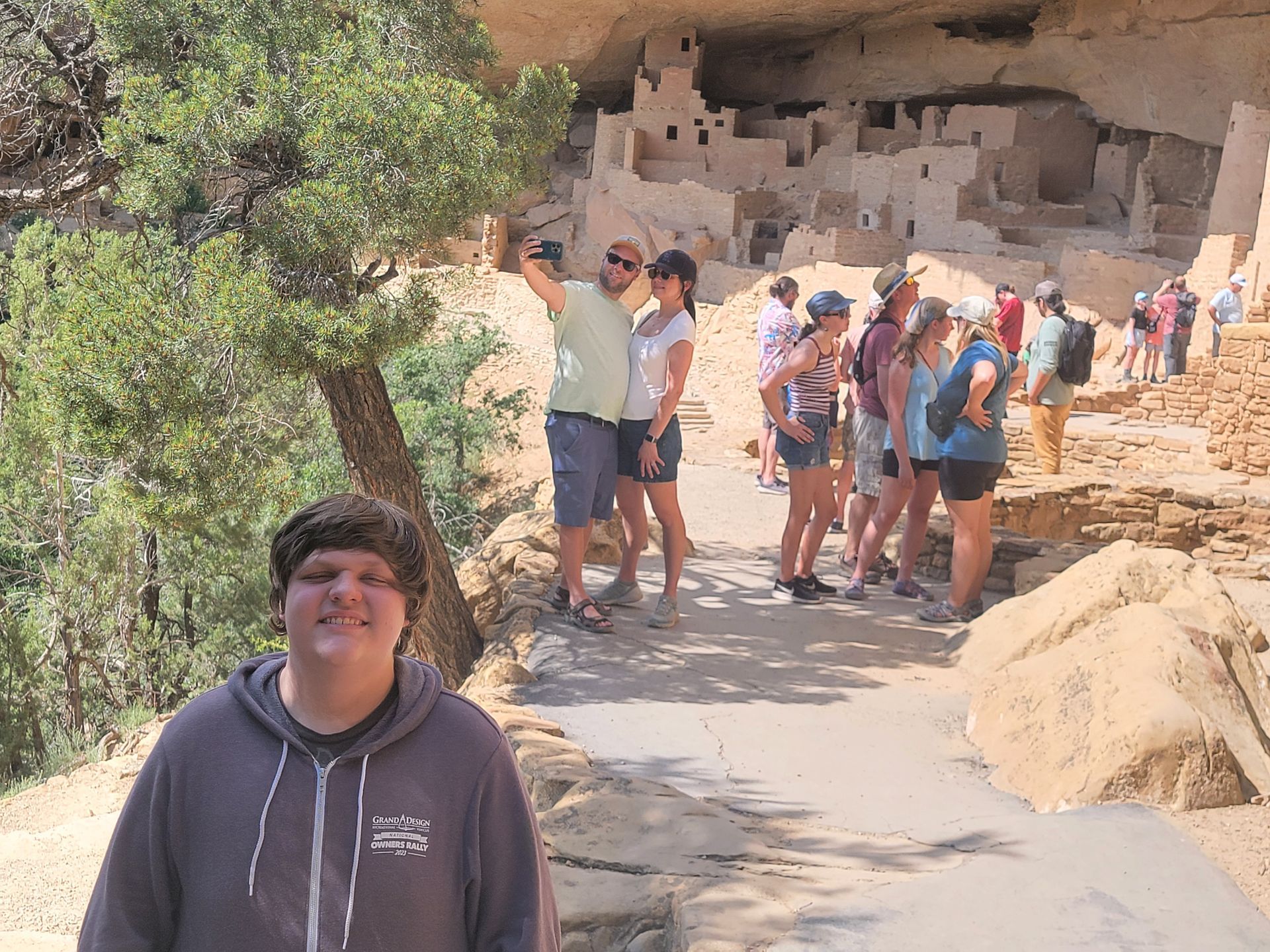 A man is standing in front of a group of people taking a selfie.