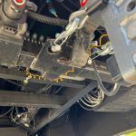 A close up of the underside of a vehicle with a lot of wires coming out of it.
