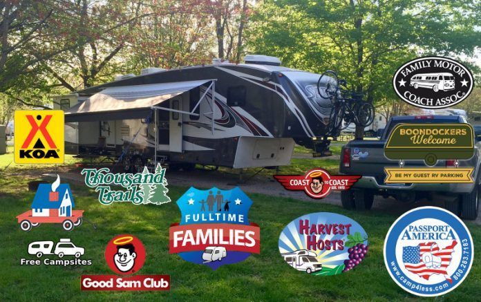A rv parked in a grassy area with various logos on it