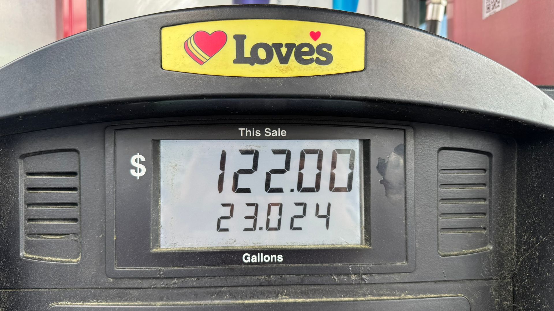 A digital display on a Love's gas pump showing a total of $122.00 for 23.024 gallons of fuel.