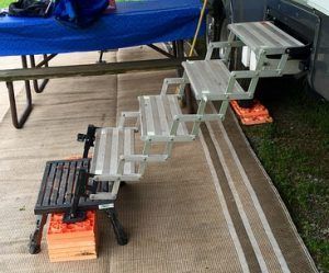 A set of stairs sitting on top of a rug next to a picnic table.