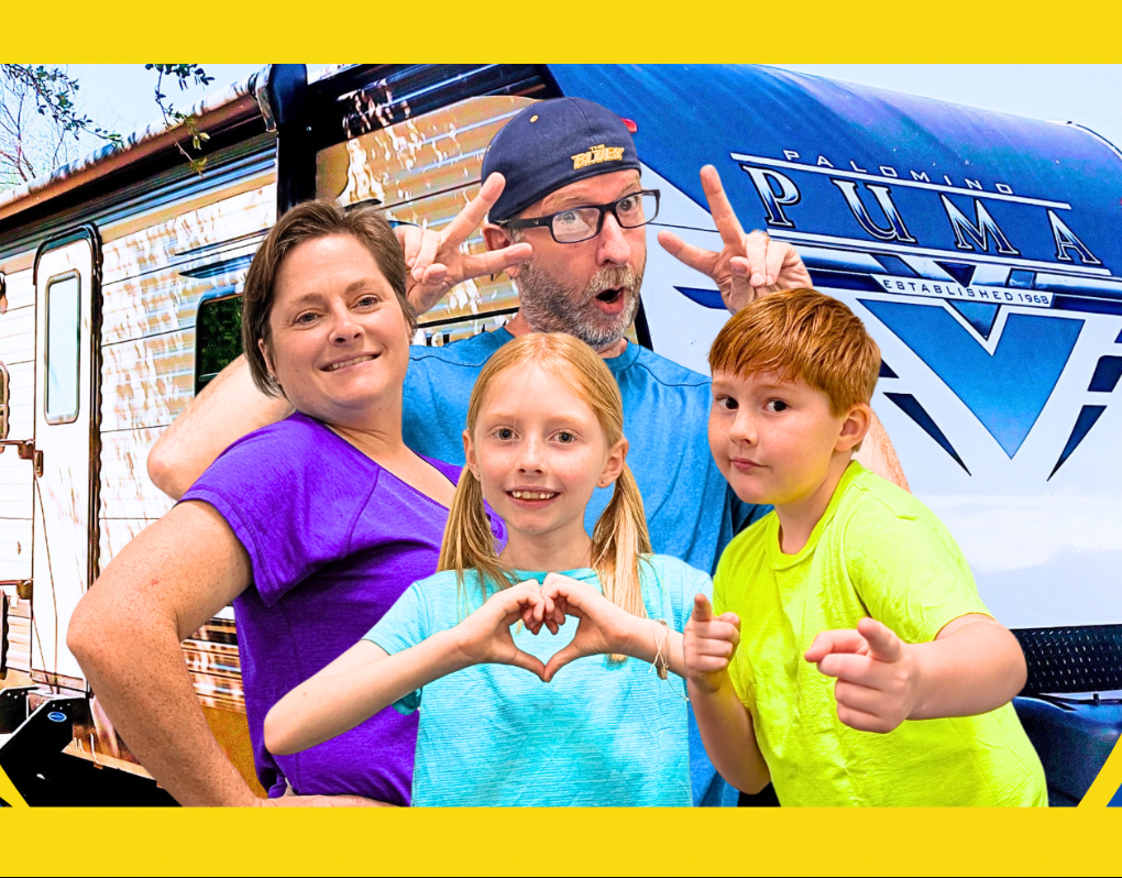 Man with glasses and hat smiles, wearing plaid shirt and red shirt, in front of a waterfall.