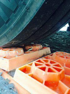 A close up of a tire sitting on top of a pair of orange blocks.