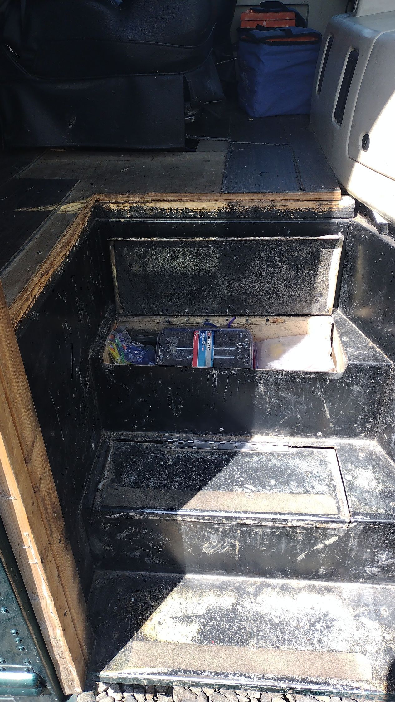 A dirty staircase in a car with a can of soda on it.