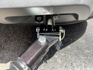 A close up of a trailer hitch attached to the back of a car.