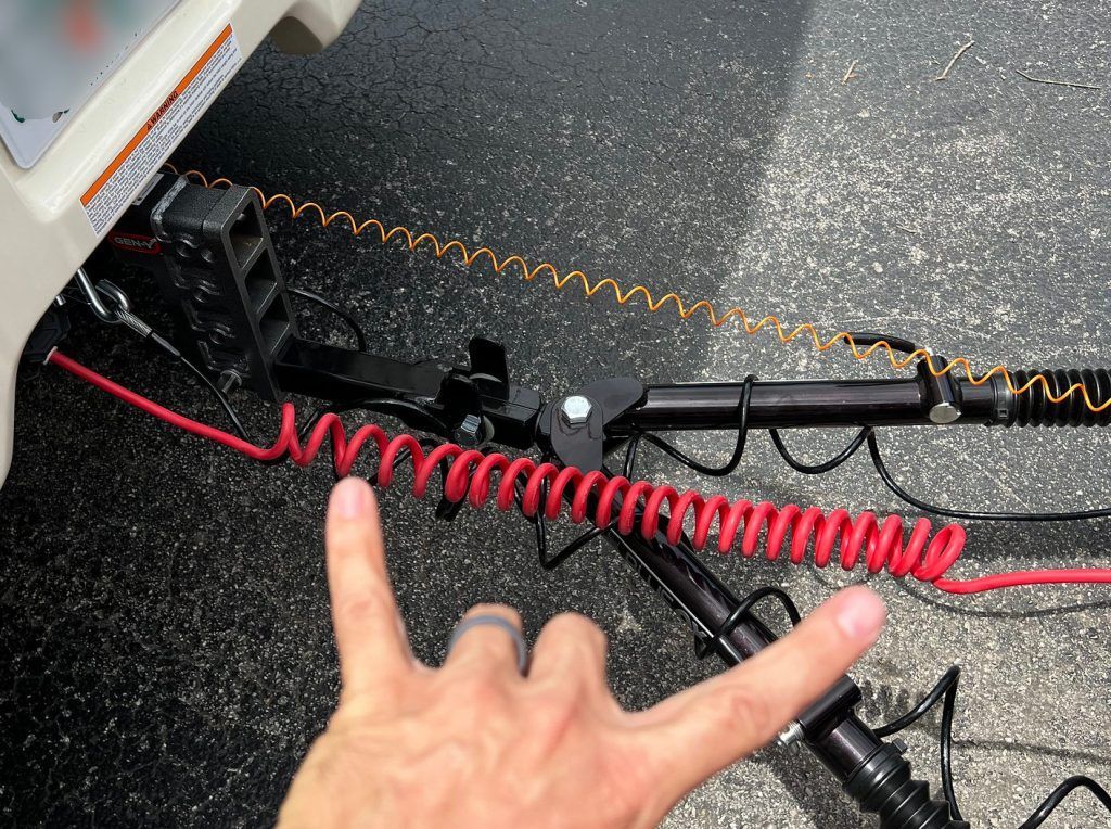 A person 's hand is pointing at a red wire.