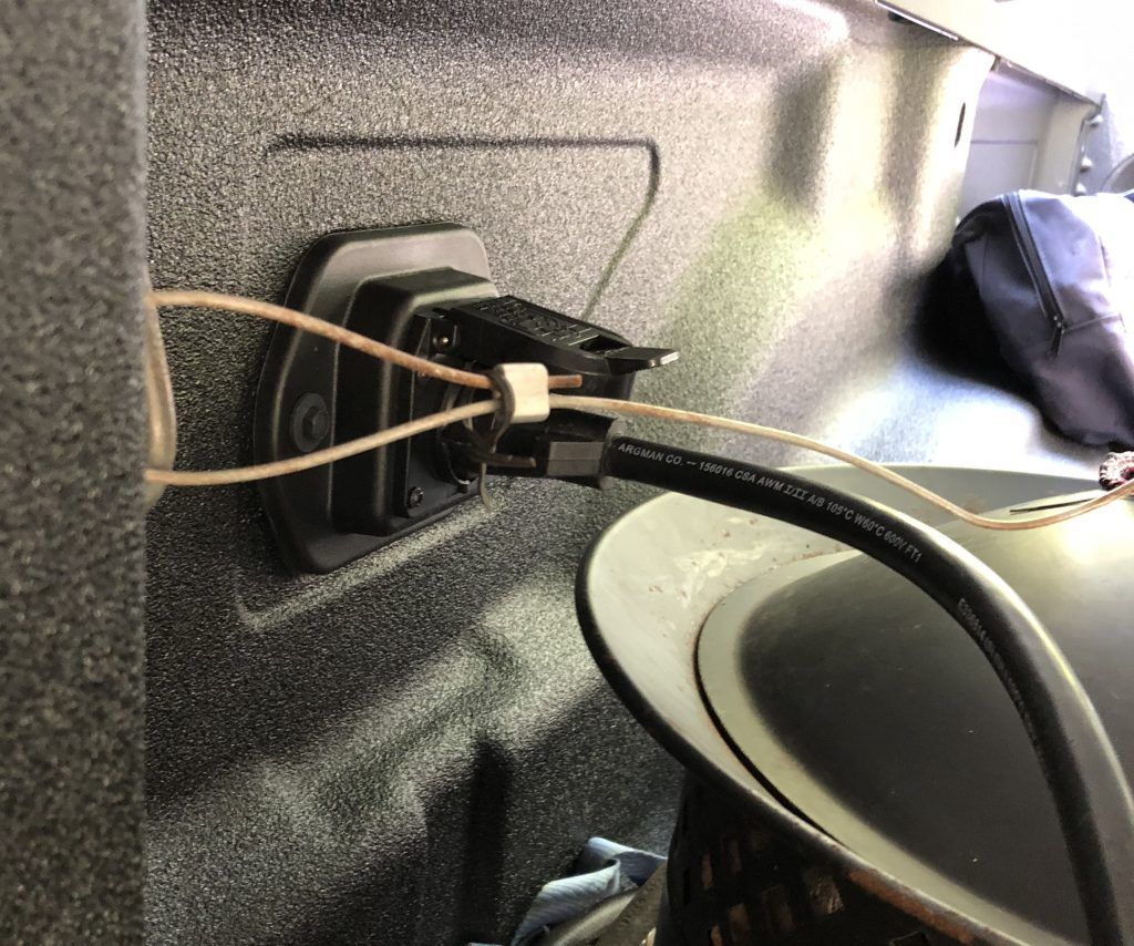 A close up of a plug in a car trunk