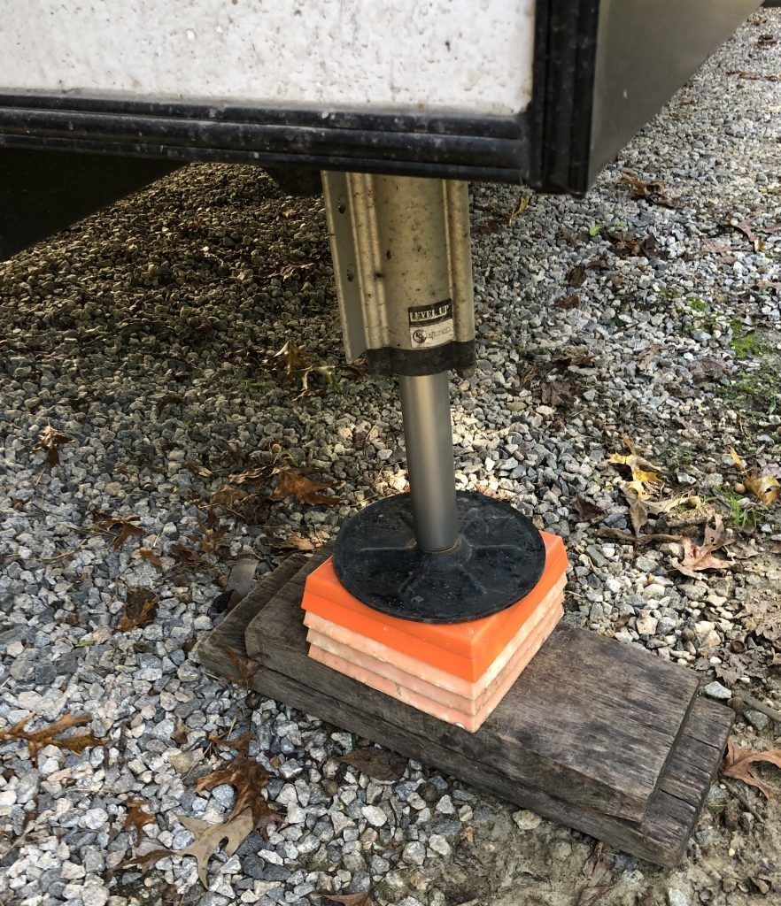 A rv is sitting on top of a wooden block.