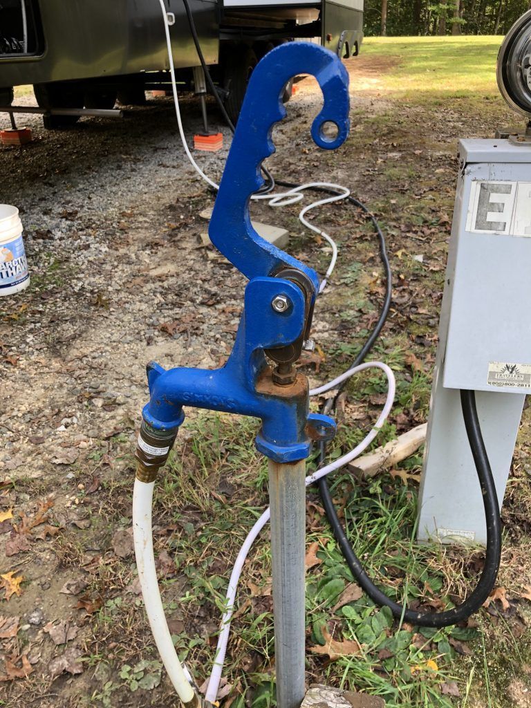 A blue water faucet with a hose attached to it.