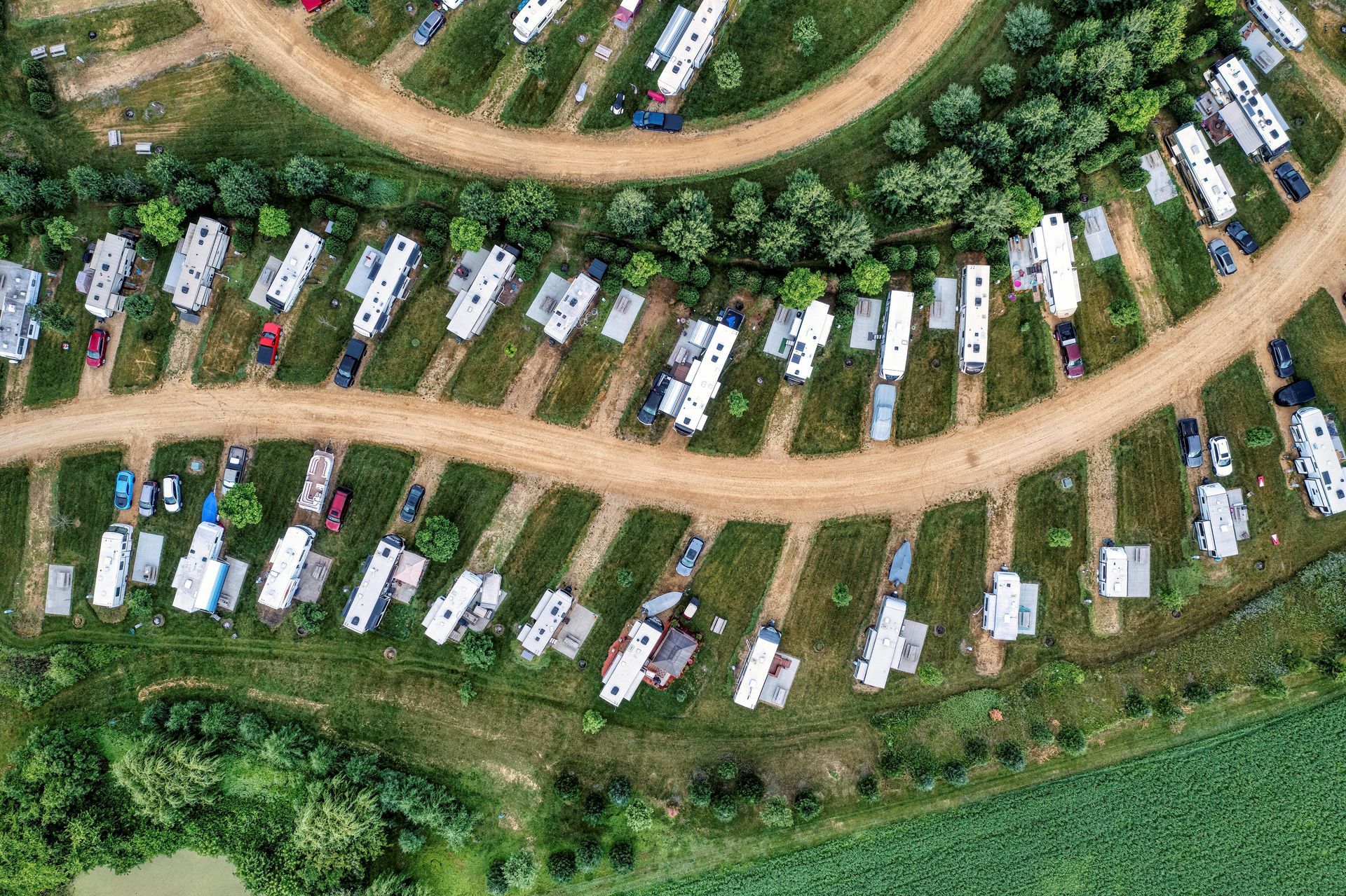 An aerial view of a campground filled with lots of tents and cars.