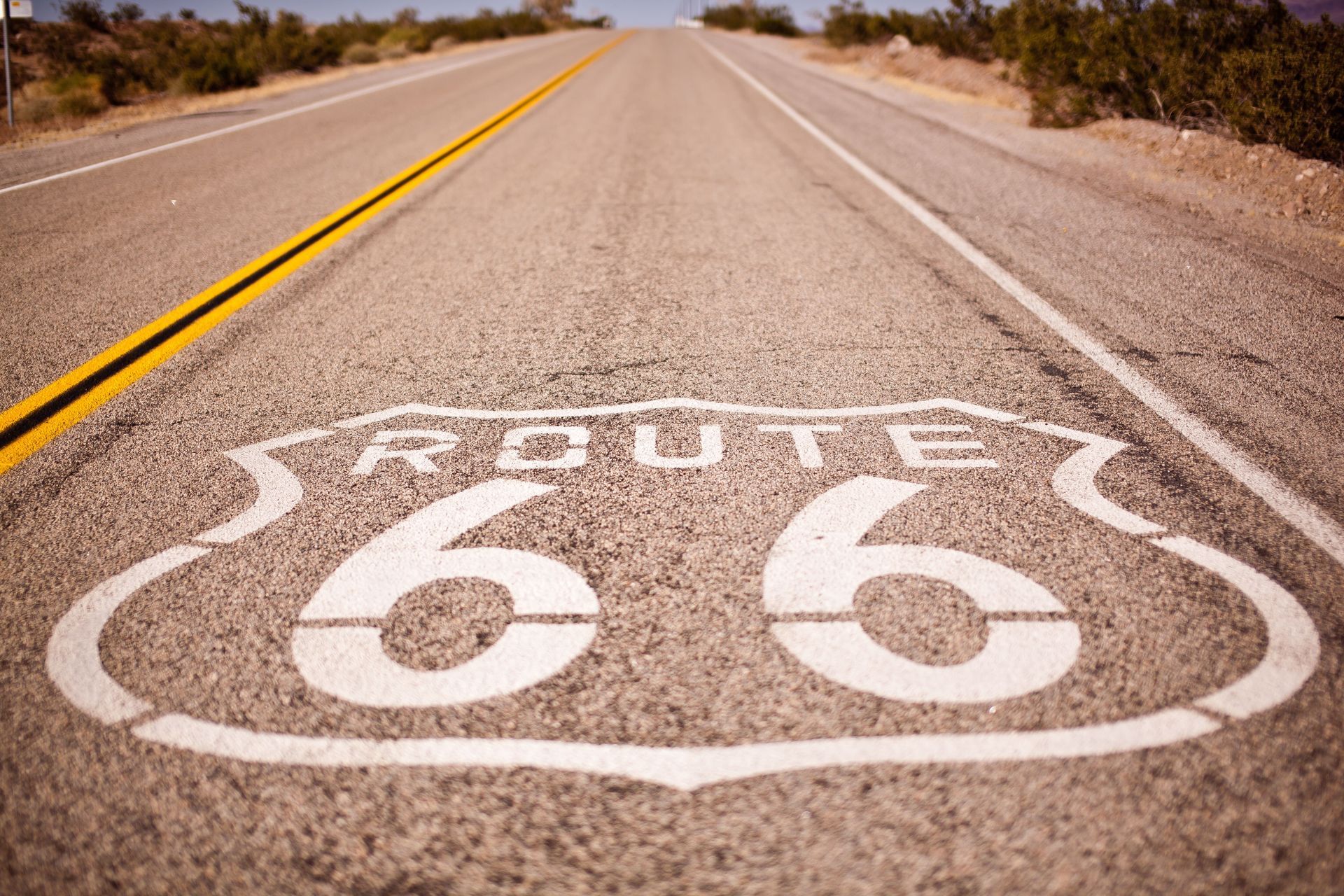 Route 66 shield painted on a deserted highway in the desert