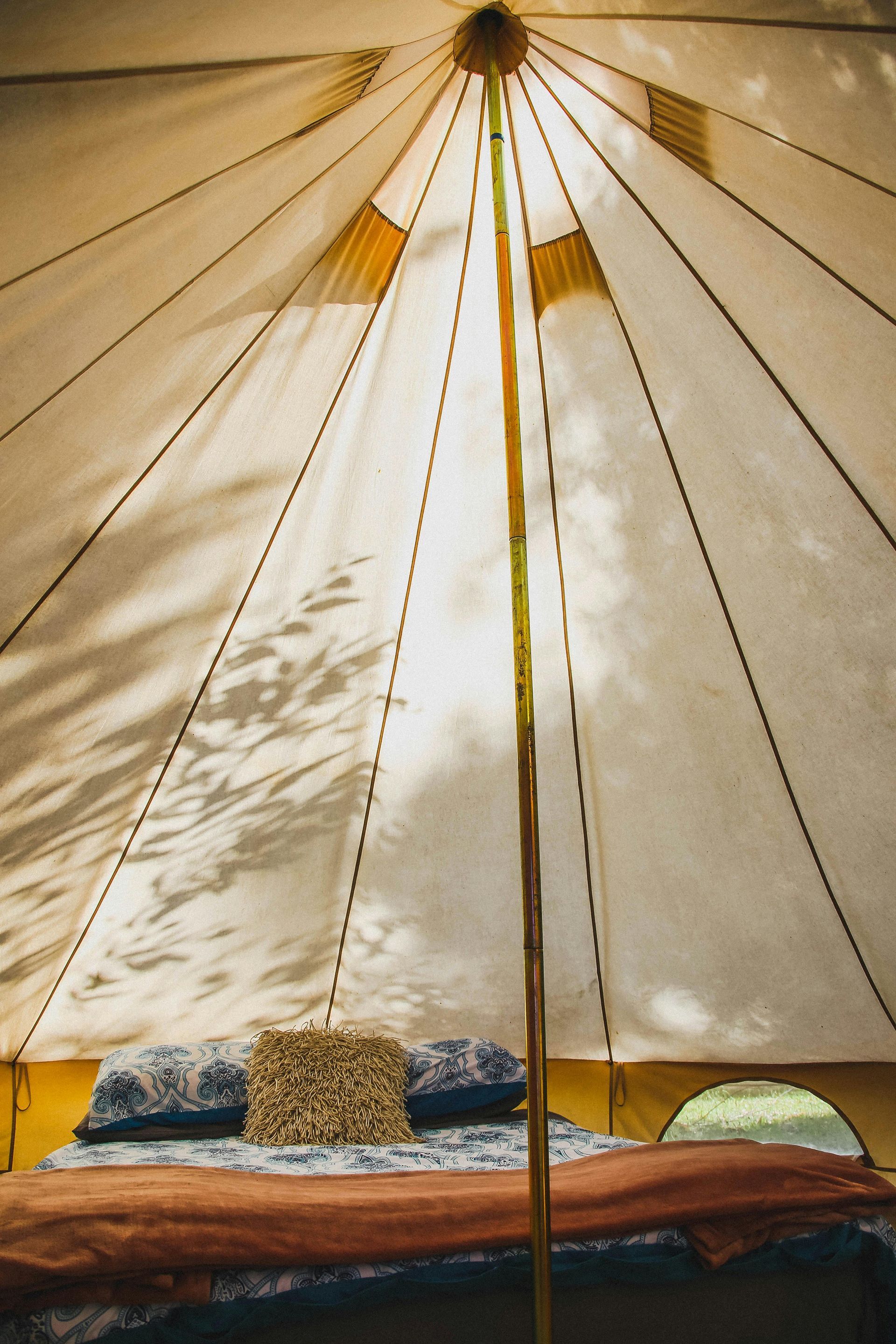 A tent with a bed and pillows inside of it.