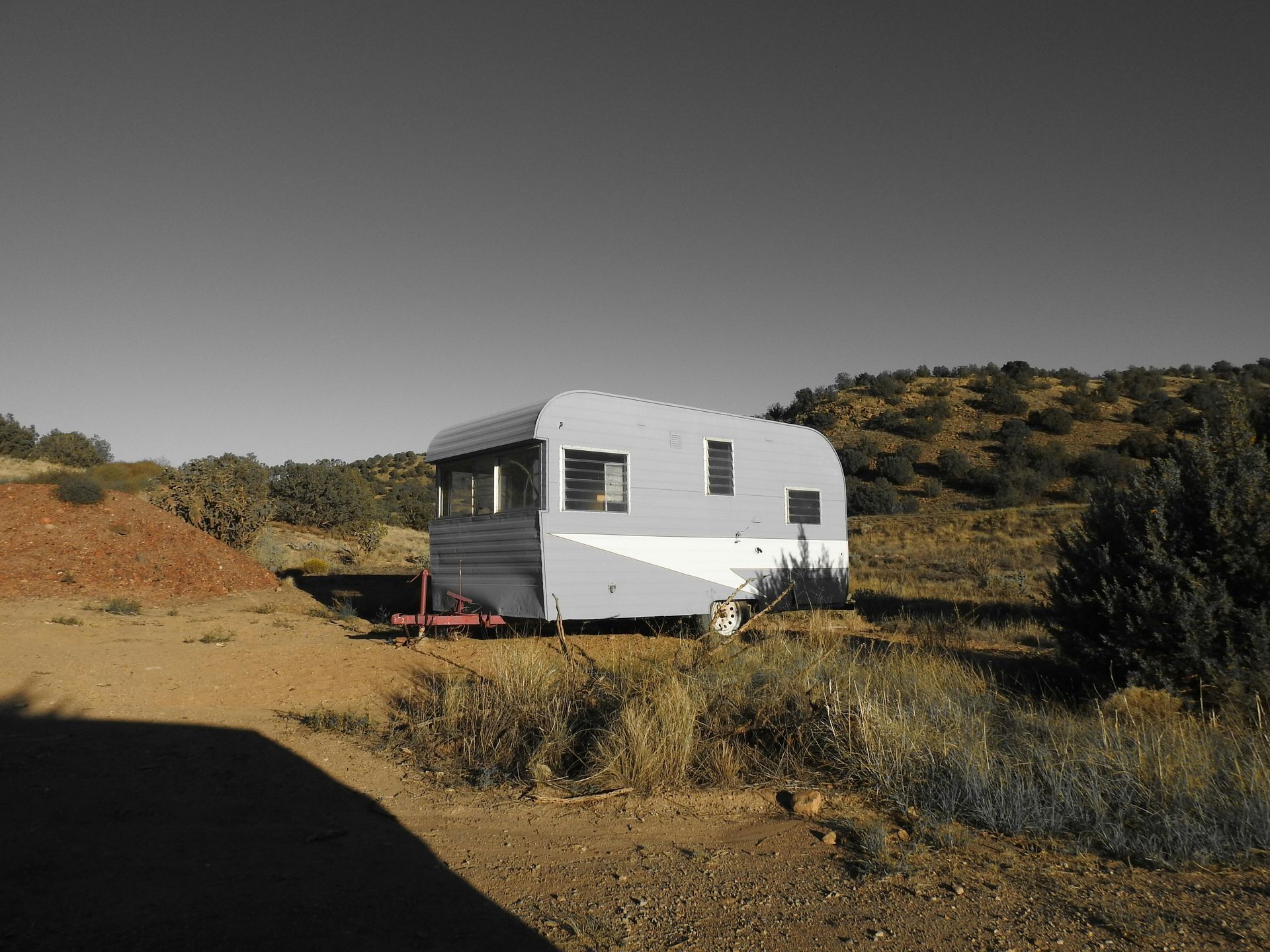 A trailer is parked in the middle of a dirt field