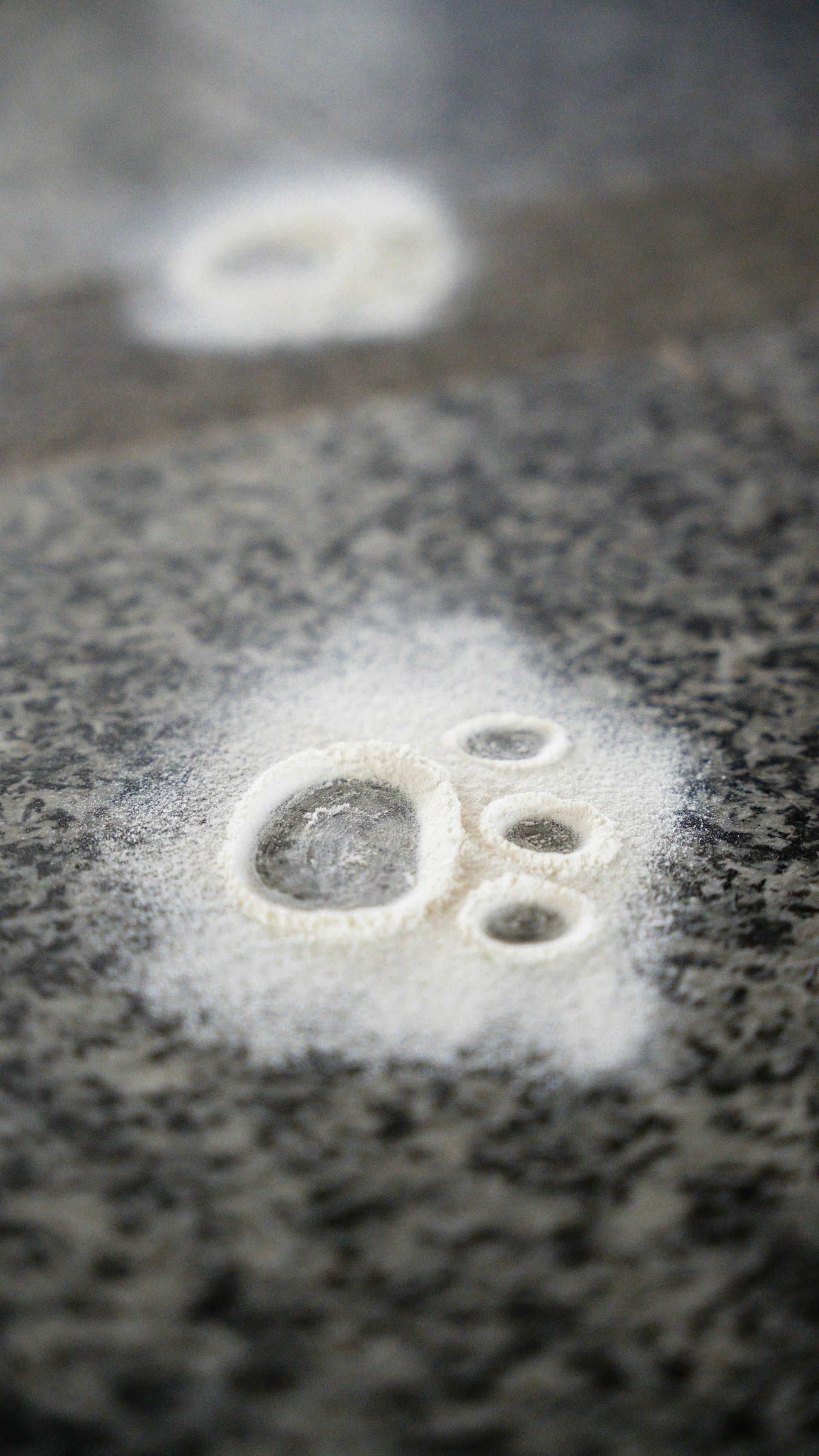 A close up of a paw print in sugar on a counter.