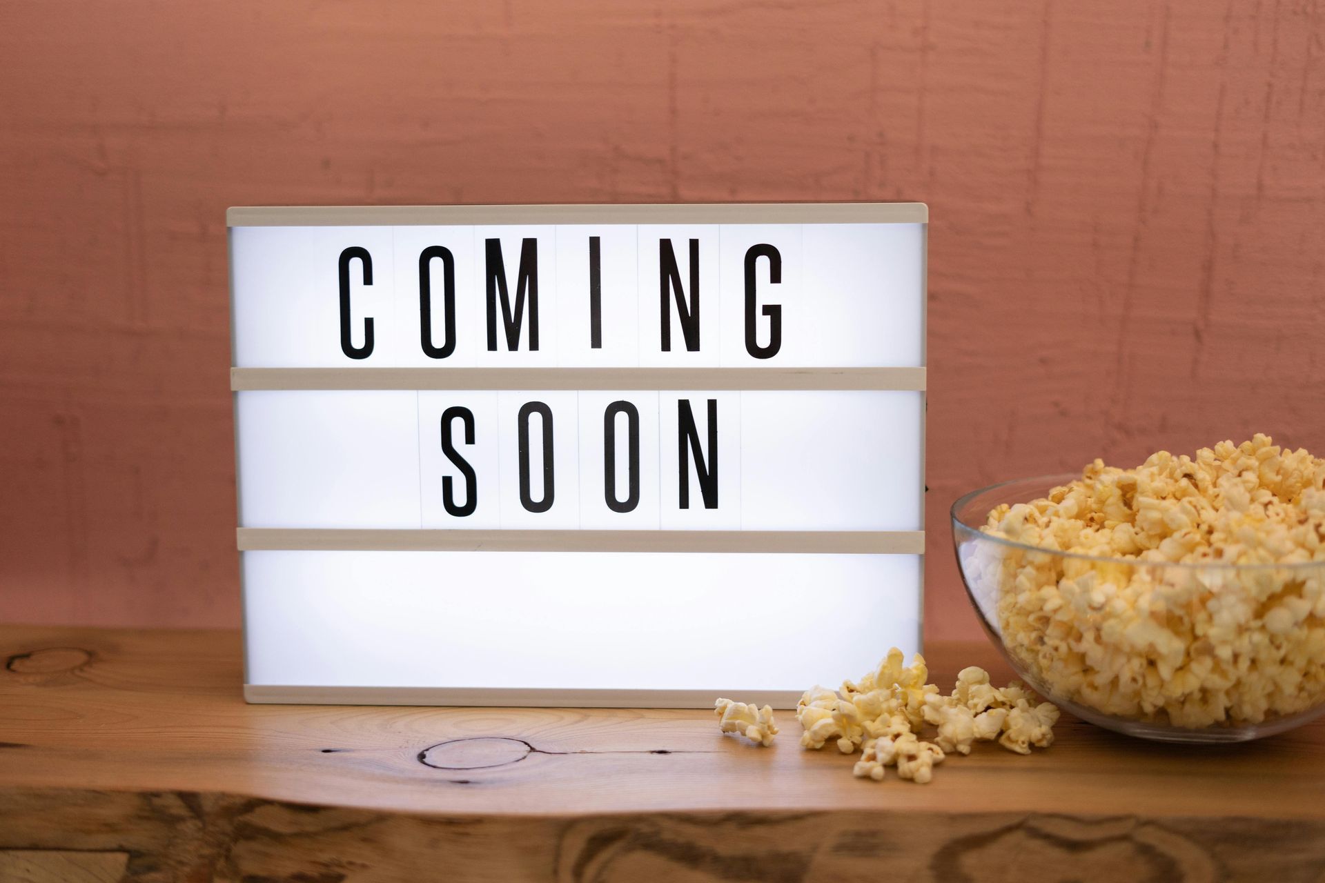 A light box that says `` coming soon '' next to a bowl of popcorn.