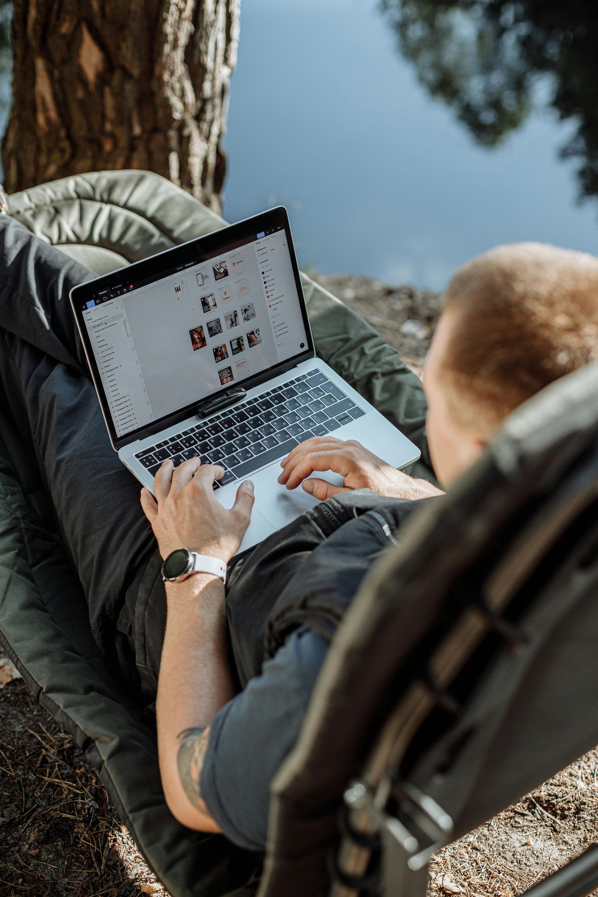 A man is laying in a chair using a laptop computer.