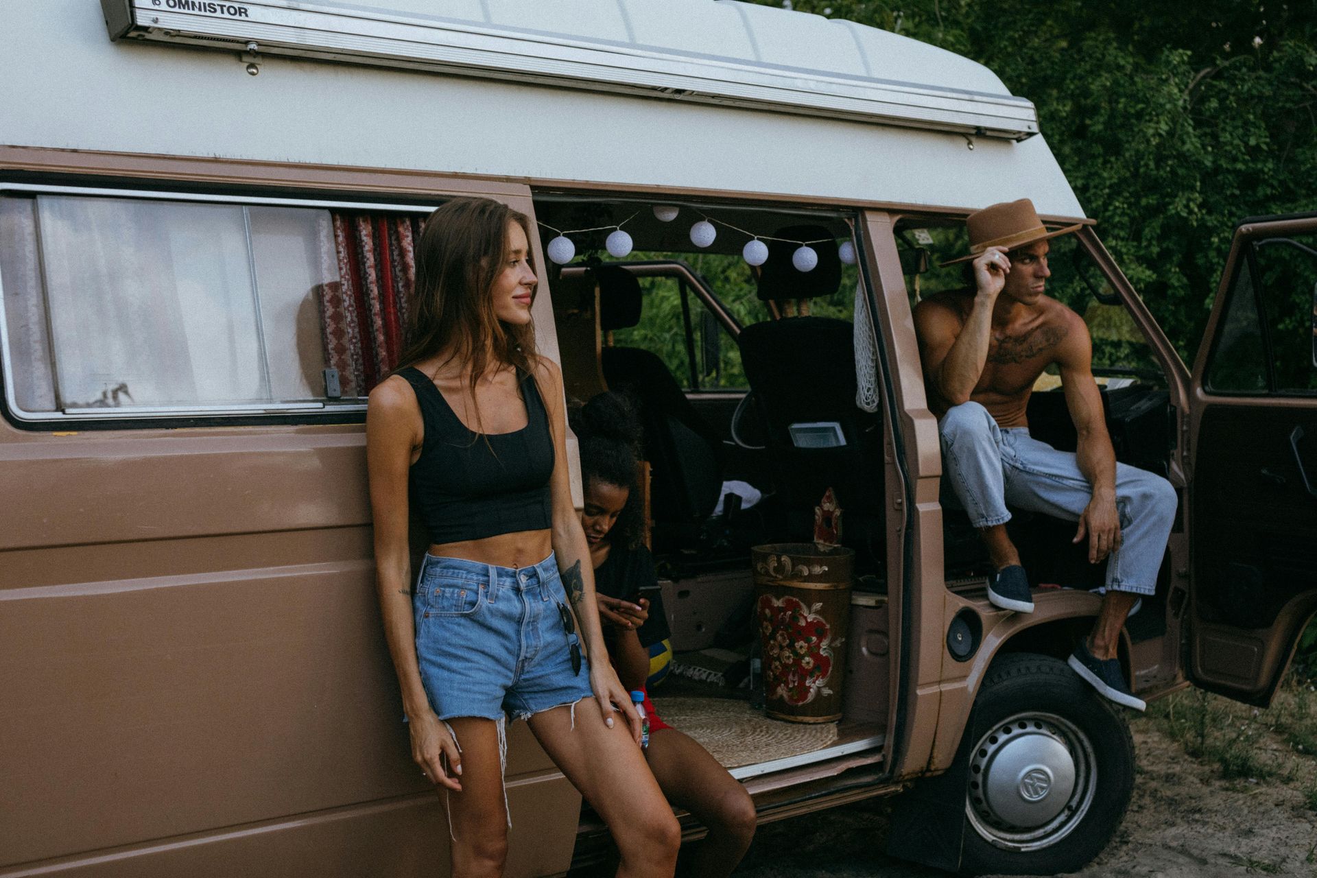 A group of people are standing next to a camper van.