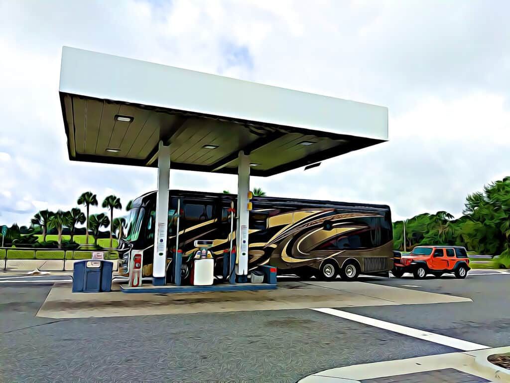 A large rv is parked at a gas station.