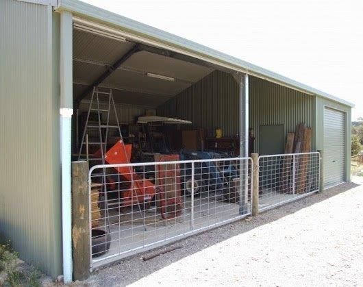 Open shed with farm equipment and a metal gate — More Than Garages Pty Ltd–Ranbuild Tamworth in Taminda, NSW