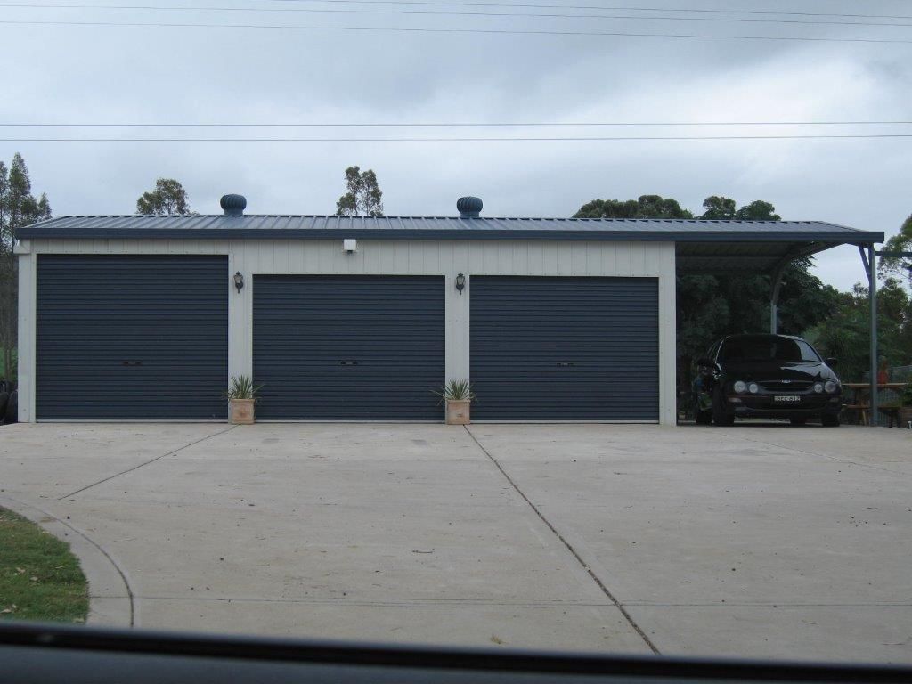 Three-door garage with dark doors and a car — More Than Garages Pty Ltd–Ranbuild Tamworth in Taminda, NSW